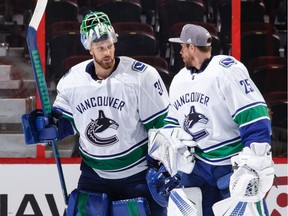 Anders Nilsson of the Vancouver Canucks, left, celebrates his win and shutout against the Ottawa Senators with teammate Jacob Markstrom at Canadian Tire Centre on Tuesday in Ottawa.