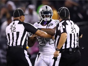 Marshawn Lynch of the Oakland Raiders is restrained after coming off the bench and shoving a referee during a scrum with the Kansas City Chiefs during their 31-30 victory over K.C. at Oakland-Alameda County Coliseum on Thursday night.