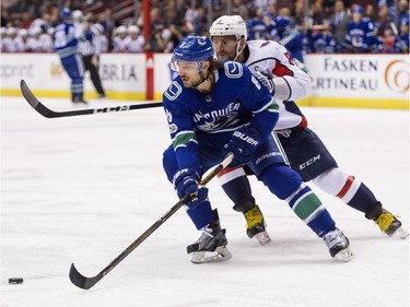 Chris Tanev #8 of the Vancouver Canucks skates with the puck while pressured by Alex Ovechkin #8 of the Washington Capitals in NHL action on October, 26, 2017 at Rogers Arena in Vancouver, British Columbia, Canada.