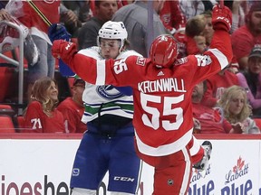 Jake Virtanen, left, collides with Niklas Kronwall during the third period.