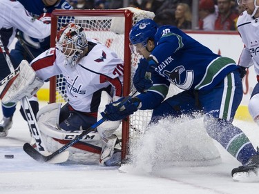 Vancouver Canucks #20 Brandon Sutter tries to wrap around Washington Capitals goalie Braden Holtby in the first period of a regular season NHL hockey game at Rogers Arena, Vancouver, October 26 2017.