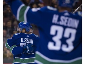 The Sedins celebrate a goal against the Jets.