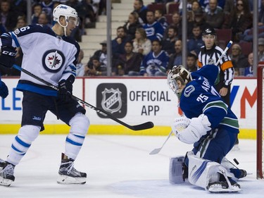 Vancouver Canucks goalie Jacob Markstrom deflects a shot from Winnipeg Jets #16 Shawn Mattias in the second period of a regular season NHL hockey game at Rogers Arena, Vancouver, October 12 2017.