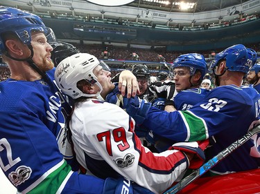 Henrik and Daniel Sedin surround Nathan Walker of the Capitals and Jake Virtanen of the Canucks.