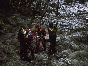 A high angle rescue is used to rescue four individuals trapped on an island in the Capilano river under the Hwy #1 bridge in North Vancouver.