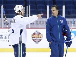 Michael Del Zotto of the Vancouver Canucks talks to head coach Travis Green during their practice at Mercedes-Benz Arena September 20, 2017 in Shanghai, China.