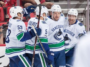 Derek Dorsett celebrates his second period goal against the Red Wings with teammates Derrick Pouliot #5, Sven Baertschi #47 and Bo Horvat.