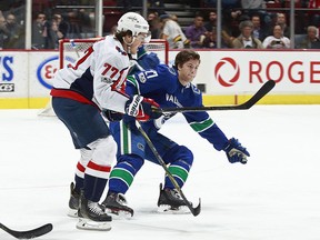 T.J. Oshie checks Ben Hutton during the Canucks ' 6-2 win over the Capitals.