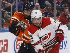Carolina Hurricanes' Elias Lindholm (28) is chased by Edmonton Oilers' Adam Larsson (6) during NHL action on Oct. 17, 2017, in Edmonton.
