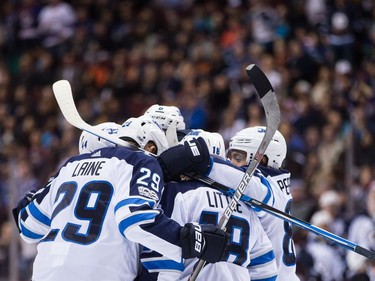 Winnipeg Jets' Josh Morrissey, from left, Patrik Laine, of Finland, Jacob Trouba, Bryan Little and Mathieu Perreault celebrate Morrissey's goal against the Vancouver Canucks during the first period of an NHL hockey game in Vancouver, B.C., on Thursday October 12, 2017.