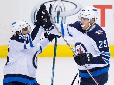Winnipeg Jets' Mathieu Perreault, left, and Patrik Laine, of Finland, celebrate Laine's goal against the Vancouver Canucks during the second period of an NHL hockey game in Vancouver, B.C., on Thursday October 12, 2017.