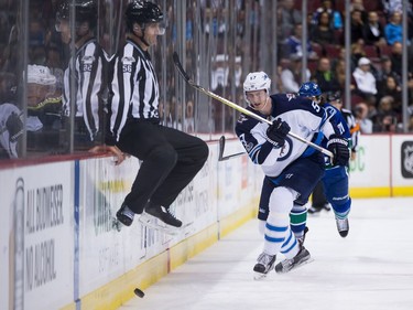 Winnipeg Jets' Tyler Myers (57) shoots the puck past linesman Mark Wheeler and into the Vancouver Canucks end during the first period of an NHL hockey game in Vancouver, B.C., on Thursday October 12, 2017.