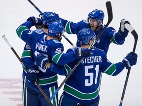 Ben Hutton, Thomas Vanek, Troy Stecher, Henrik Sedin celebrate Vanek's goal against the Ottawa Senators in Vancouver on Tuesday.