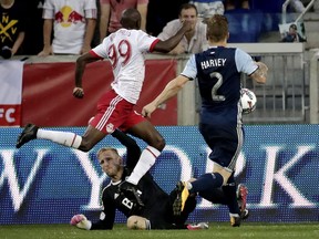 New York Red Bulls forward Bradley Wright-Phillips (99) gets the ball by Vancouver Whitecaps goalkeeper David Ousted, bottom, while scoring a goal during the second half of an MLS soccer match, Saturday, Oct. 7, 2017, in Harrison, N.J.