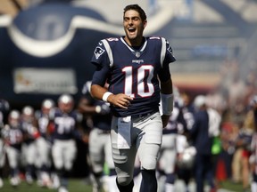 Then-New England Patriots quarterback Jimmy Garoppolo charges onto the field before an NFL game against the Houston Texans in Foxborough, Mass., on Sept. 24, 2017.