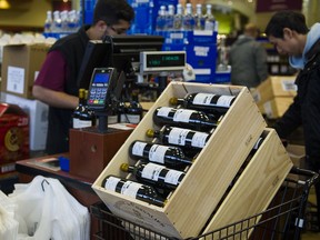 VANCOUVER, B.C.: OCTOBER 15, 2016 – A cashier scans a customer's favourite wines during BC Liquor Stores' annual release of highly prized Bordeaux wines in Vancouver, B.C. on October, 15, 2016.