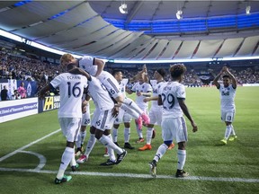 Vancouver Whitecaps' Tim Parker (26) leaps on top of Aly Ghazal and Kendall Waston as they celebrate Waston's goal against the San Jose Earthquakes during the second half of an MLS playoff soccer game in Vancouver on Wednesday October 25, 2017.