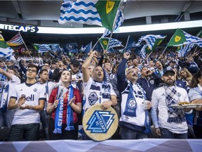 Vancouver Whitecaps fans cheer on the team before an MLS playoff soccer game against the Seattle Sounders.