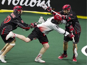 Calgary Roughnecks' Curtis Dickson shoots between Vancouver Stealth (80) Peter McFetridge and (6) Curtis Hodgson to score in a regular-season NLL game at the Langley Events Centre on Jan 14.