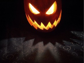 A Jack-o-lantern pumpkin glows in the night.