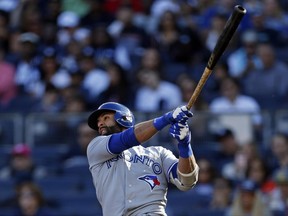 Jose Bautista hits a sacrifice fly against the New York Yankees on Oct. 1.