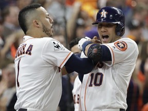 Houston Astros' Yuli Gurriel is congratulated by Carlos Correa after hitting a home run during the first inning of Game 3 of baseball's World Series against the Los Angeles Dodgers Friday, Oct. 27, 2017, in Houston. (AP Photo/David J. Phillip)