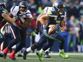 Quarterback Russell Wilson #3 of the Seattle Seahawks rushes against the Houston Texans at CenturyLink Field on October 29, 2017 in Seattle, Washington.