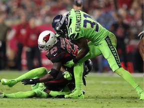 Running back Adrian Peterson #23 of the Arizona Cardinals is tackled by strong safety Kam Chancellor #31. The Seahawks have already lost Richard Sherman for the season and may also lose Chancellor for their Monday game against the Atlanta Falcons.