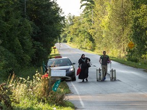 This file photo taken on August 20, 2017 shows a cab dropping off a couple of asylum seekers at the US/Canada border near Champlain, New York.