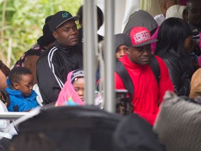 Refugees waiting to be processed by the Royal Canadian Mounted Police after crossing the Canada/US border near Hemmingford, Quebec. Canada said November 21, 2017 it is ready to deal with an influx of asylum seekers after Washington announced it would soon end protections granted to Haitians following a deadly 2010 earthquake.