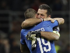 Italy goalkeeper Gianluigi Buffon is hugged by teammate Andrea Belotti after their team was eliminated in the World Cup qualifying play-off second leg soccer match between Italy and Sweden, at the Milan San Siro stadium, Italy, Monday, Nov. 13, 2017.