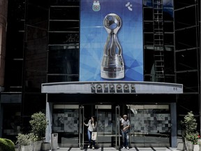 People walk out of the sports marketing company Torneos y Competencias office in Buenos Aires, Argentina, Thursday, Nov. 16, 2017. The former CEO of Torneos y Competencias Alejandro Burzaco, testified on Tuesday that the former President of the Argentine Football Association, AFA, Julio Grondona, demanded bribes to help cover what he was owed for his 2010 vote that helped Qatar land the tournament.