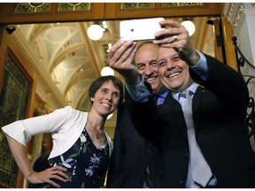 Green party MLAs Sonia Furstenau, Andrew Weaver and Adam Olsen take a picture outside the legislative assembly.