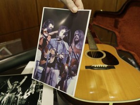 Garry Shrum, a music memorabilia specialist at Heritage Auctions, holds a photo of a 1963 Martin D-28 acoustic guitar that belonged to Bob Dylan.