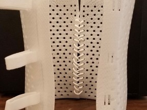A prototype of a 3-D-printed scoliosis brace made out of polypropylene, with velcro straps.