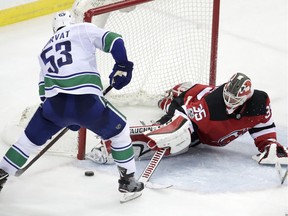 New Jersey Devils goalie Cory Schneider (35) blocks a shot by Vancouver Canucks center Bo Horvat (53) during the third period of an NHL hockey game, Friday, Nov. 24, 2017, in Newark, N.J. T