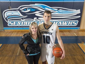 Seycove Secondary boys' basketball coach Teresa Ross and star player Christopher Ross, who is her son, update their family photo album at the North Vancouver school on Wednesday.