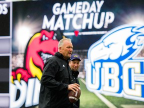 UBC Thunderbirds head coach Blake Nill walks in front of a billboard promoting their against the Calgary Dinos during CIS Canada West football action in Calgary. Nill's T-Birds face the Dinos for the Hardy Cup on Saturday.