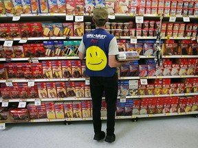 An employee restocks a shelf in the grocery section of a Walmart.