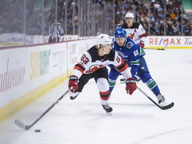 New Jersey Devils' Jesper Bratt, front, is chased by Vancouver Canucks' Markus Granlund as he skates with the puck during the first period of an NHL hockey game in Vancouver on Wednesday night.