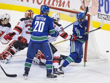 Vancouver Canucks' Derek Dorsett, right, is checked into the net by New Jersey Devils' Damon Severson (28) during the second period.