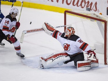 New Jersey Devils' goalie Cory Schneider reaches for the puck as Adam Henrique watches during the second period. He earned a shutout in the Devils' 2-0 win at Rogers Arena in Vancouver Wednesday night.