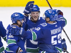 Vancouver Canucks' Sven Baertschi, left, of Switzerland, Brock Boeser, centre, and Bo Horvat celebrate Boeser's second goal against the Pittsburgh Penguins during the second period of Saturday's game at Rogers Arena.