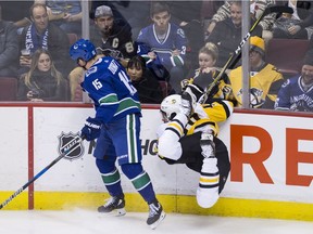 Pittsburgh Penguins' Frank Corrado, right, crashes head-first into the boards after colliding with Vancouver Canucks' Derek Dorsett during the second period of Saturday's 4-2 Canucks win at Rogers Arena.