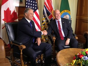 B.C. Premier John Horgan, right, shakes hands with Washington state Gov. Jay Inslee as the two meet at the legislature in Victoria on Nov. 21, 2017.