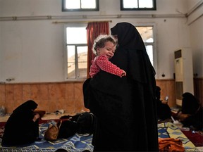 The wife of a suspected member of the Islamic State group waits on the western front line to be questioned last month after fleeing the centre of Raqqa, Syria.