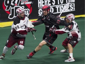 Vancouver Stealth Jon Harnett, centre, chases after Colorado Mammoth Callum Crawford, left, while dogged by the Mammoth's Jeremy Noble in a regular-season NLL game at the Langley Events Centre on April 22. Harnett could be sidelined by an injury suffered during training camp.