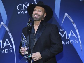 FILE - In this Nov. 8, 2017 file photo, musician Garth Brooks poses in the press room with the award for entertainer of the year at the 51st annual CMA Awards in Nashville, Tenn. The 55-year-old singer released "Garth Brooks: The Anthology Part 1 The First Five Years" on Tuesday. It includes a book written by Brooks, five albums _ including songs never heard before _ and behind-the-scenes focused on the years 1989-1994. (Photo by Evan Agostini/Invision/AP, File)