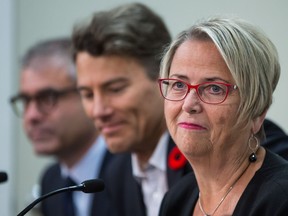 Mental Health and Addictions Minister Judy Darcy, Vancouver Mayor Gregor Robertson, centre, and addictions specialist Dr. Keith Ahamad listen during a news conference in Vancouver on Nov. 10 concerning a new drug-checking service in the city.