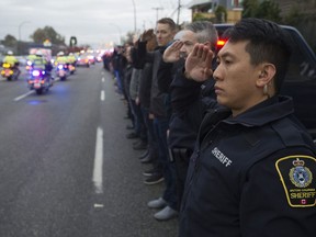 Vancouver police, B.C. Ambulance, sheriffs and other first responders line Grandview Highway in Vancouver to pay respect to Abbotsford Police Const. John Davidson as his body is brought back to Abbotsford in a procession of police vehicles.